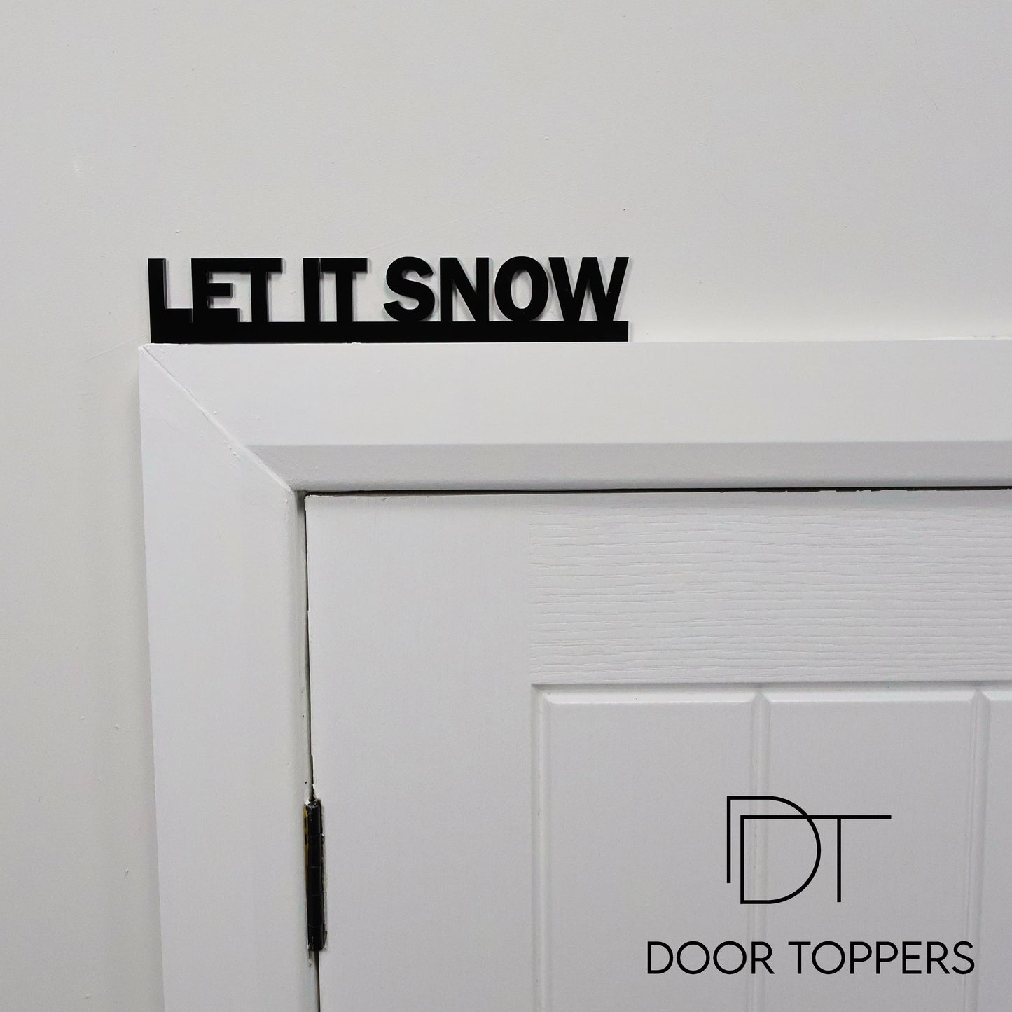 LET IT SNOW acrylic sign displayed above a door, a modern Christmas decoration handmade in the UK.