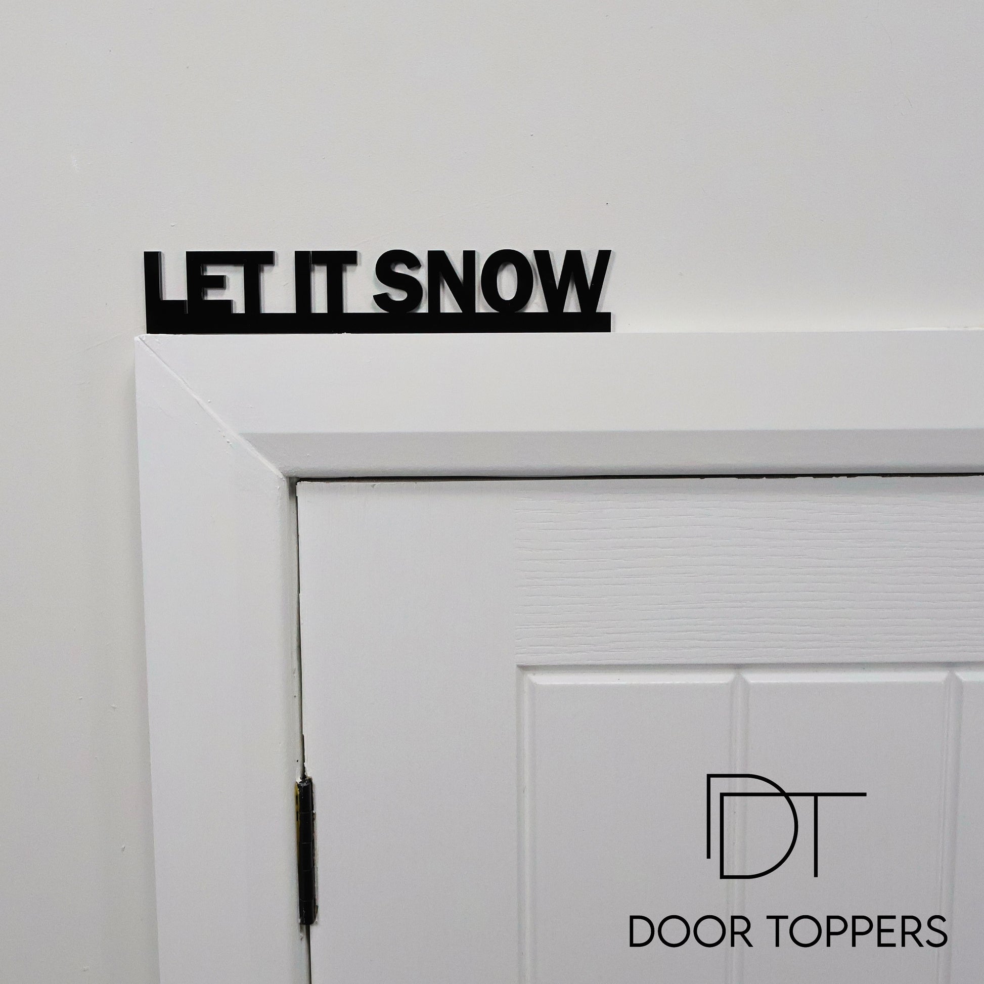 LET IT SNOW acrylic sign displayed above a door, a modern Christmas decoration handmade in the UK.