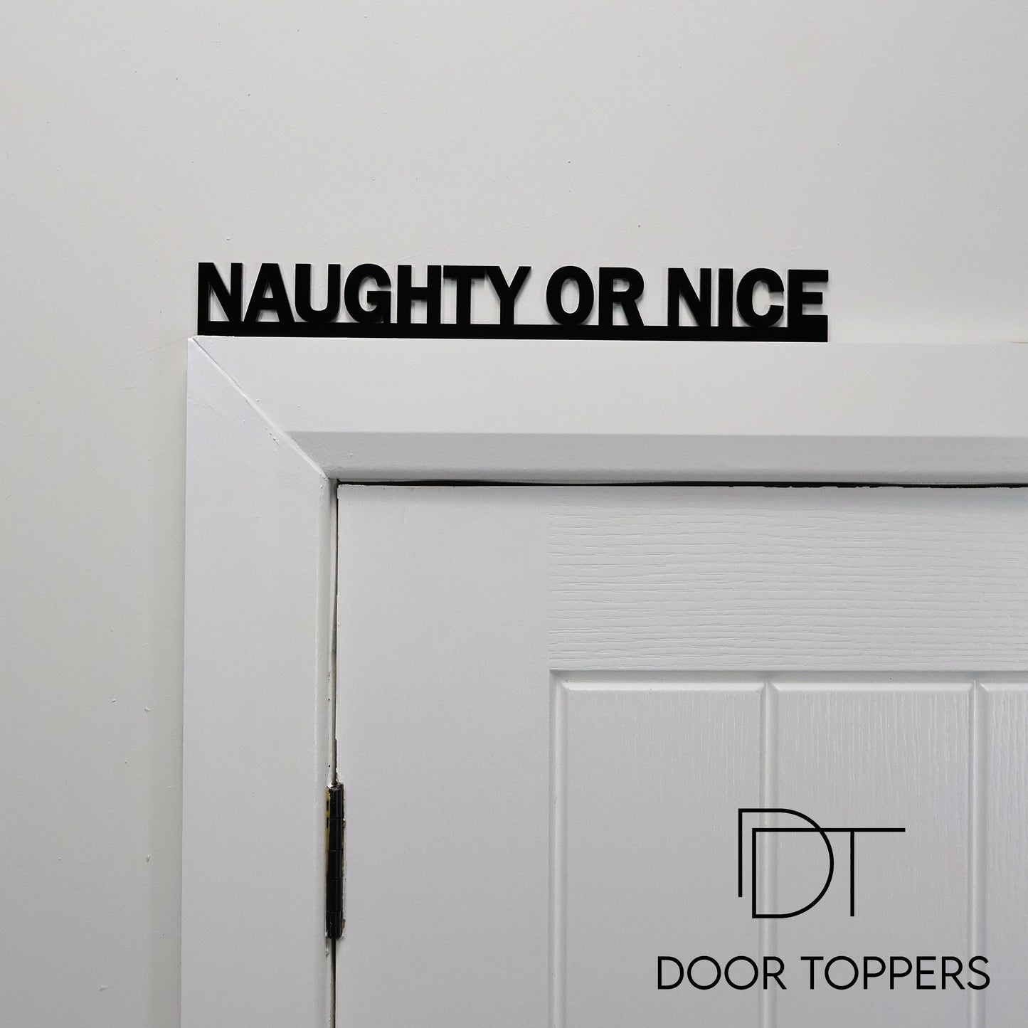 NAUGHTY OR NICE acrylic sign displayed above a door, a funny Christmas decoration handmade in the UK.