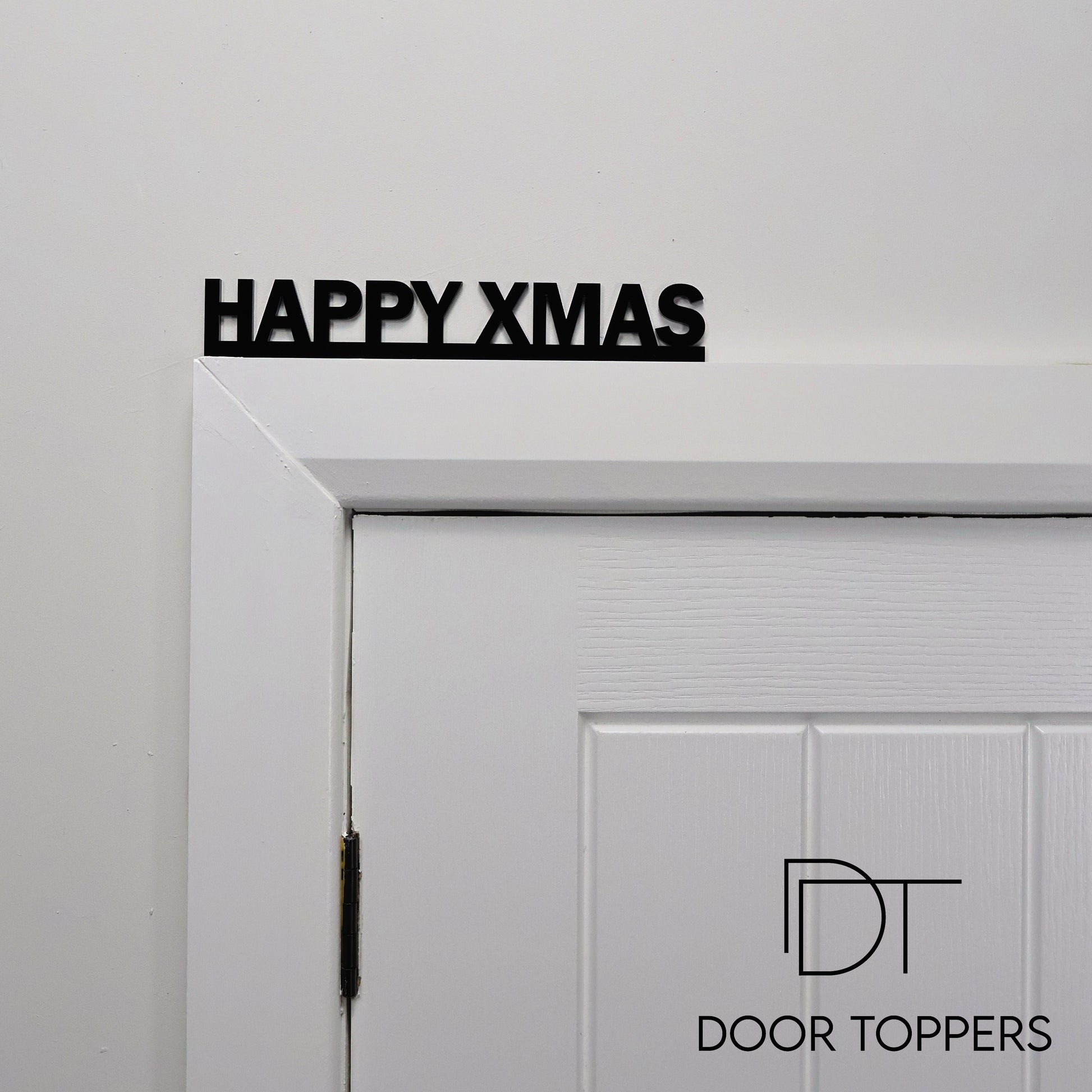 HAPPY XMAS acrylic sign displayed above a door, a modern Christmas decoration handmade in the UK.