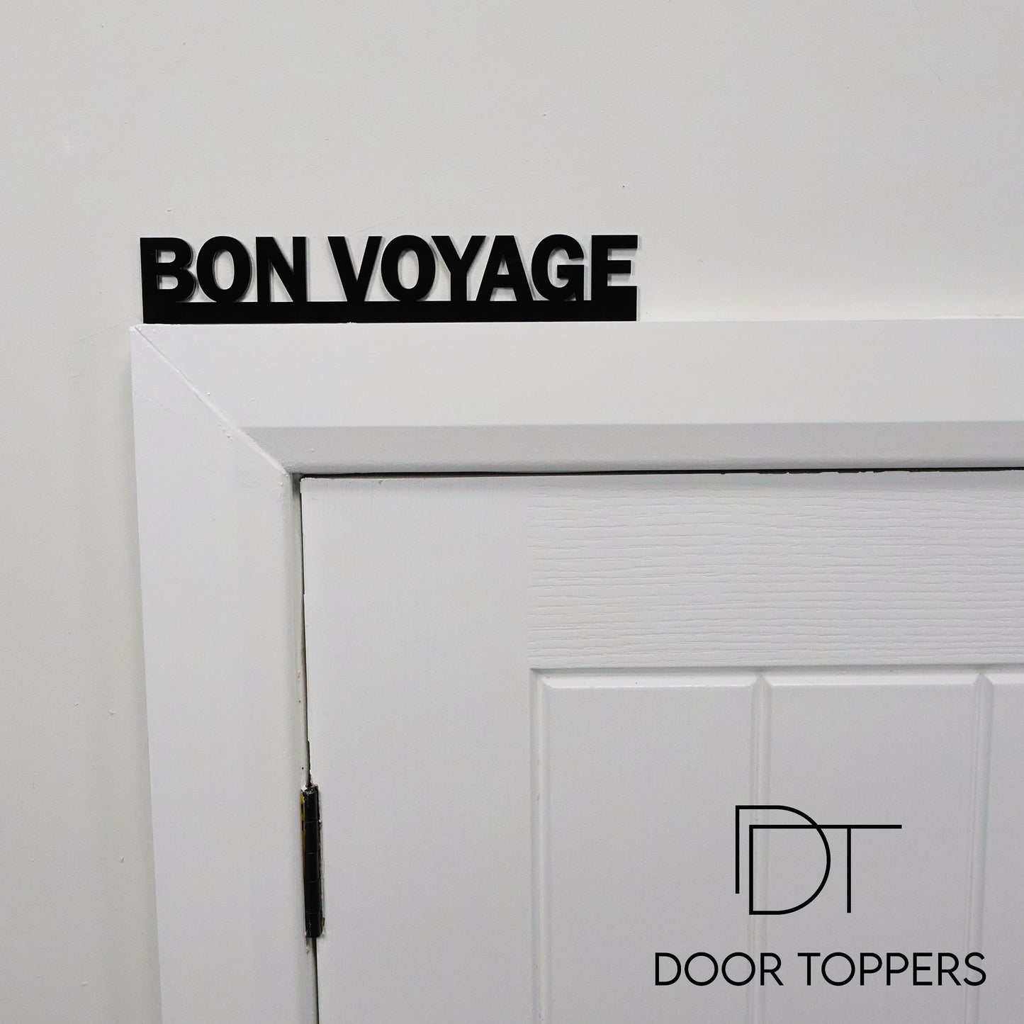 BON VOYAGE black acrylic Door Topper displayed above a hallway door.
