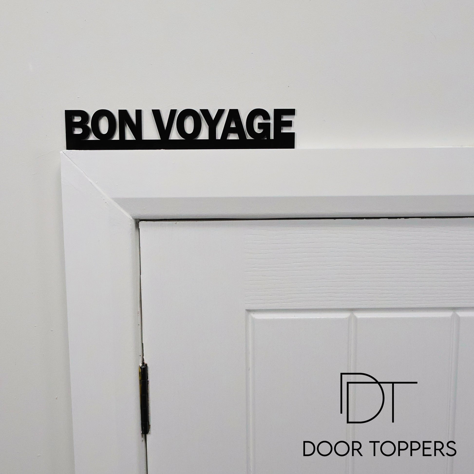 BON VOYAGE black acrylic Door Topper displayed above a hallway door.