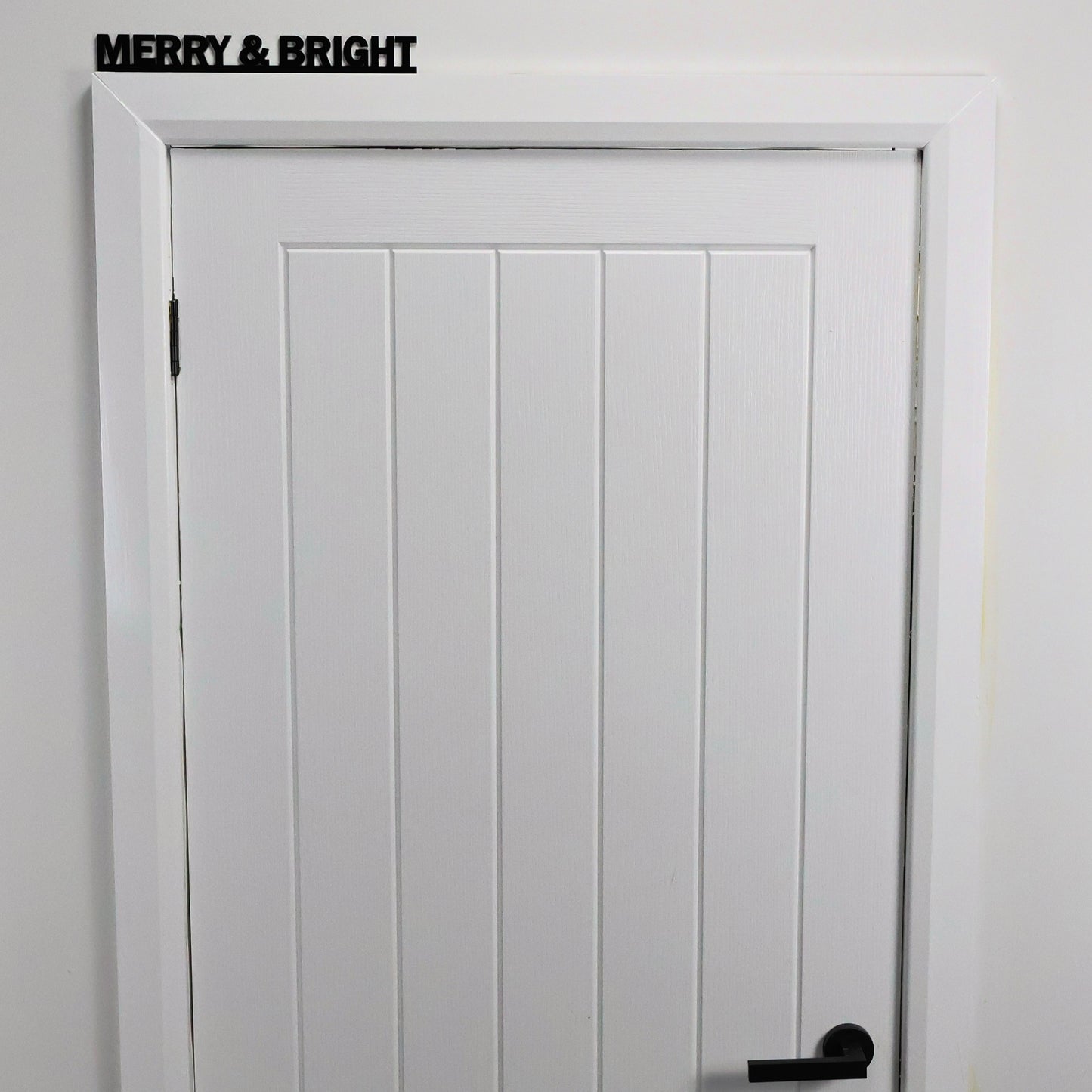 Close-up of glossy black acrylic MERRY & BRIGHT lettering