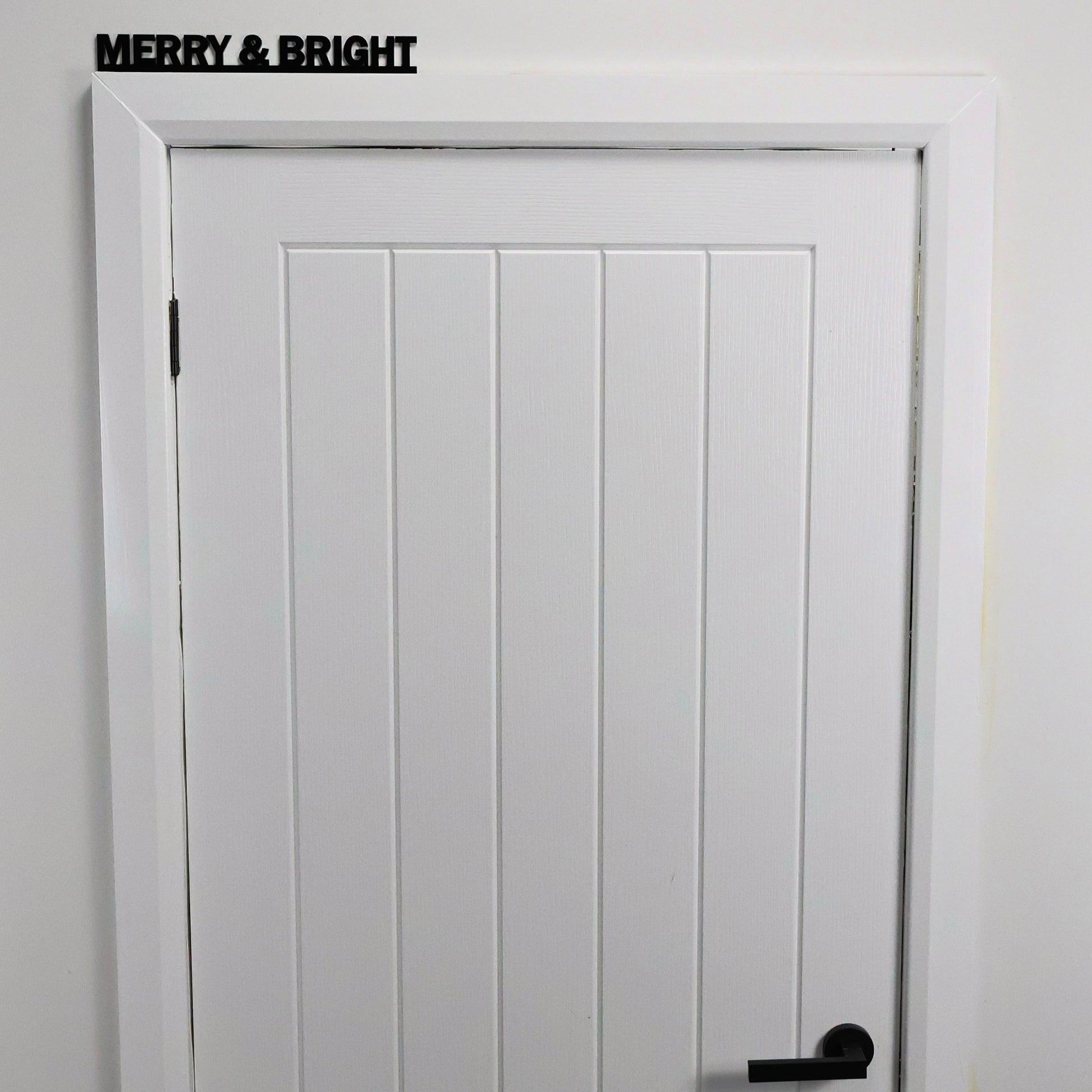 Close-up of glossy black acrylic MERRY & BRIGHT lettering