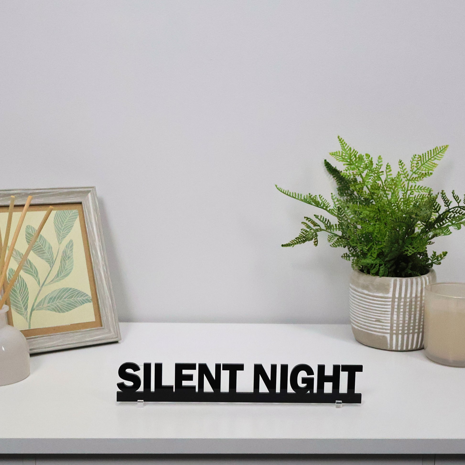 SILENT NIGHT sign shown freestanding beside candles and fairy lights