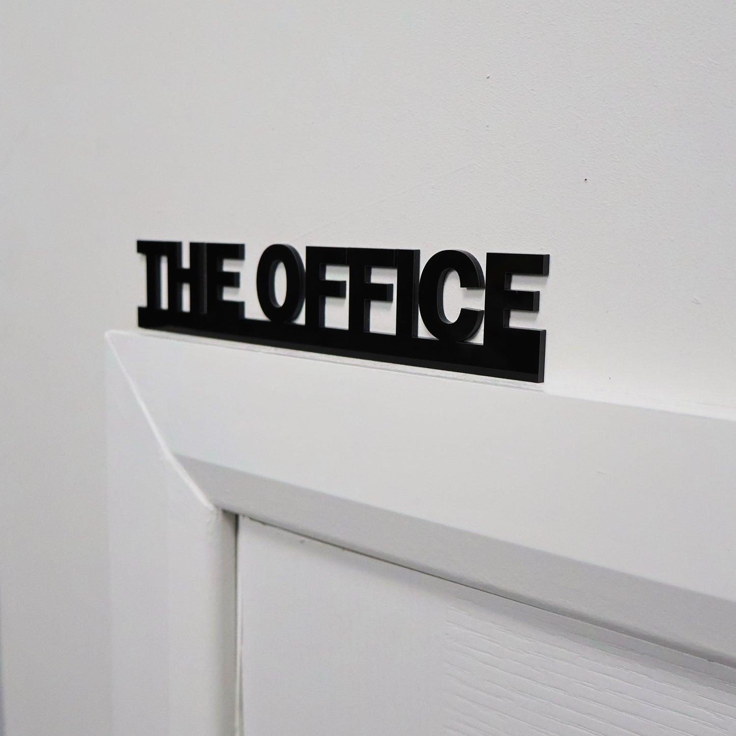 Modern office wall sign displayed above door frame – clean contemporary design