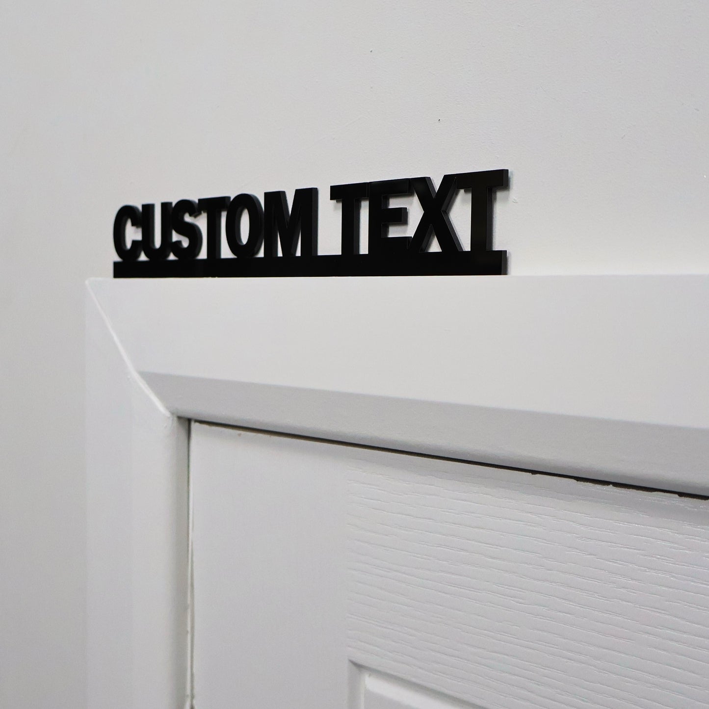 Close-up of custom text black acrylic wall art mounted on a wall – sleek personalised decor piece, modern handmade UK design