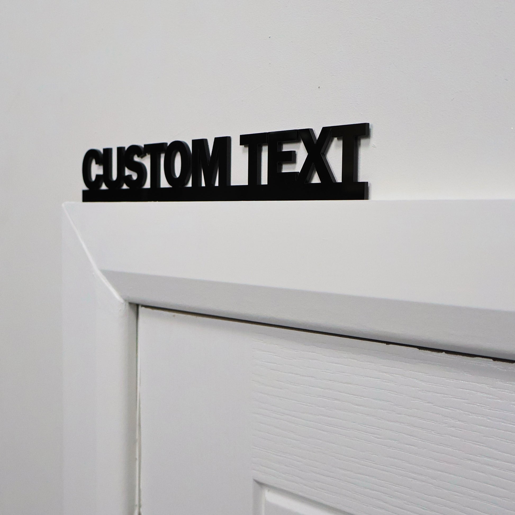 Close-up of custom text black acrylic wall art mounted on a wall – sleek personalised decor piece, modern handmade UK design