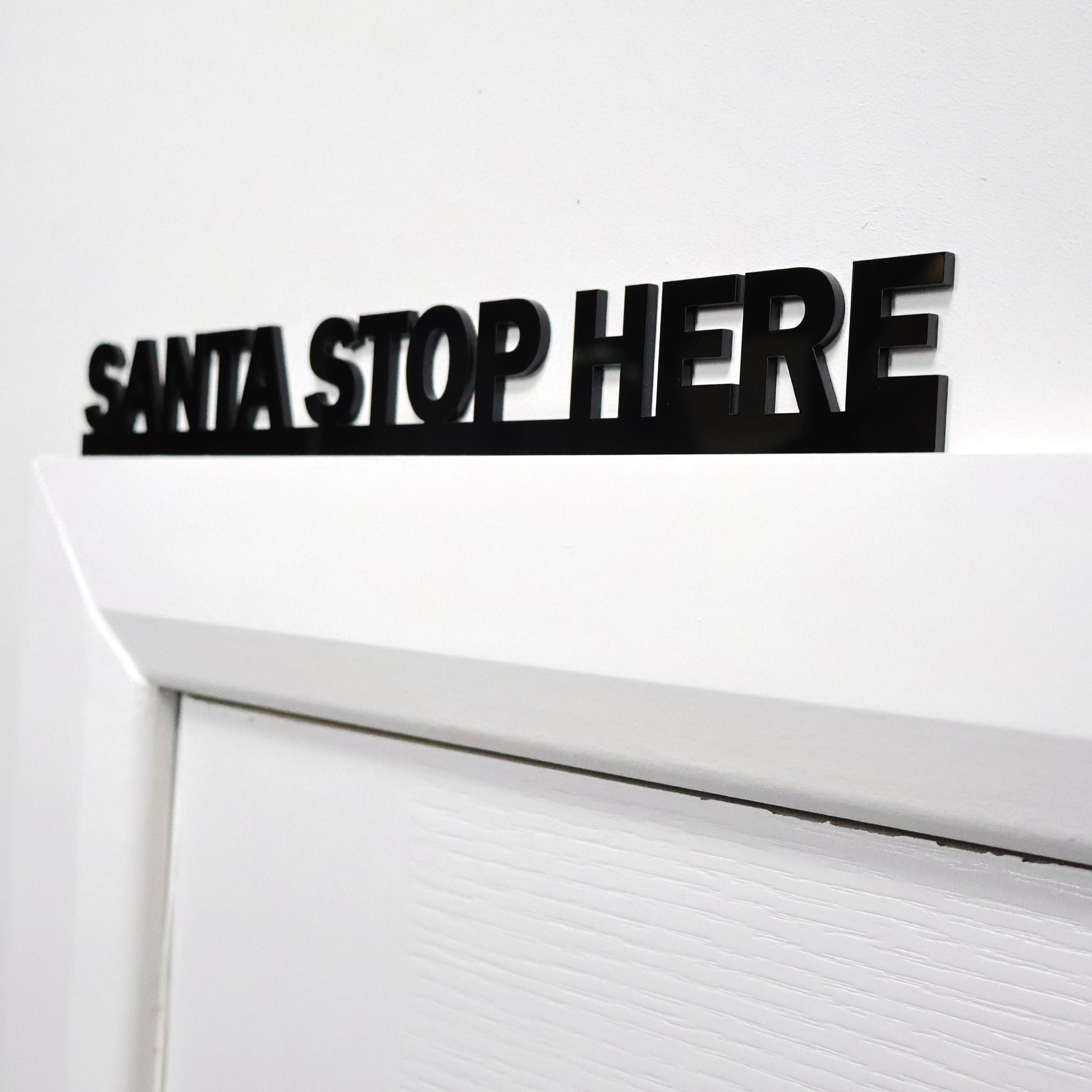 Close-up of SANTA STOP HERE lettering – sleek gloss recycled acrylic finish