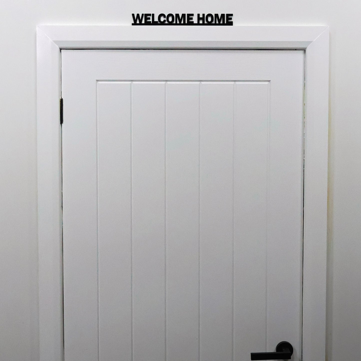 WELCOME HOME acrylic sign displayed above a doorway in modern hallway