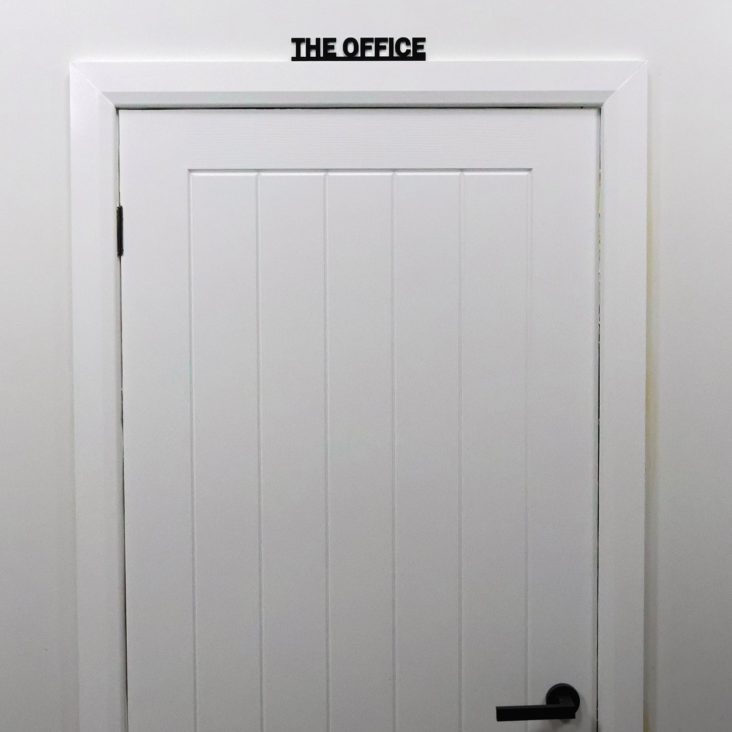 THE OFFICE sign styled with neutral work accessories in home office