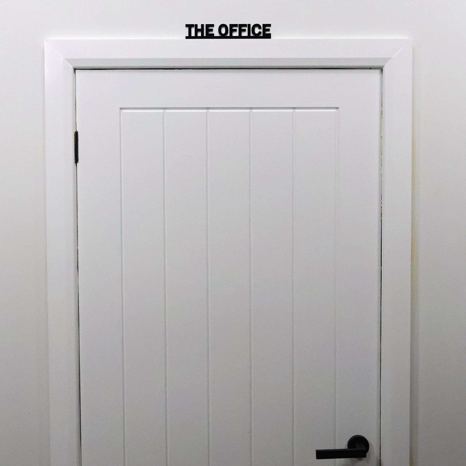 THE OFFICE sign styled with neutral work accessories in home office