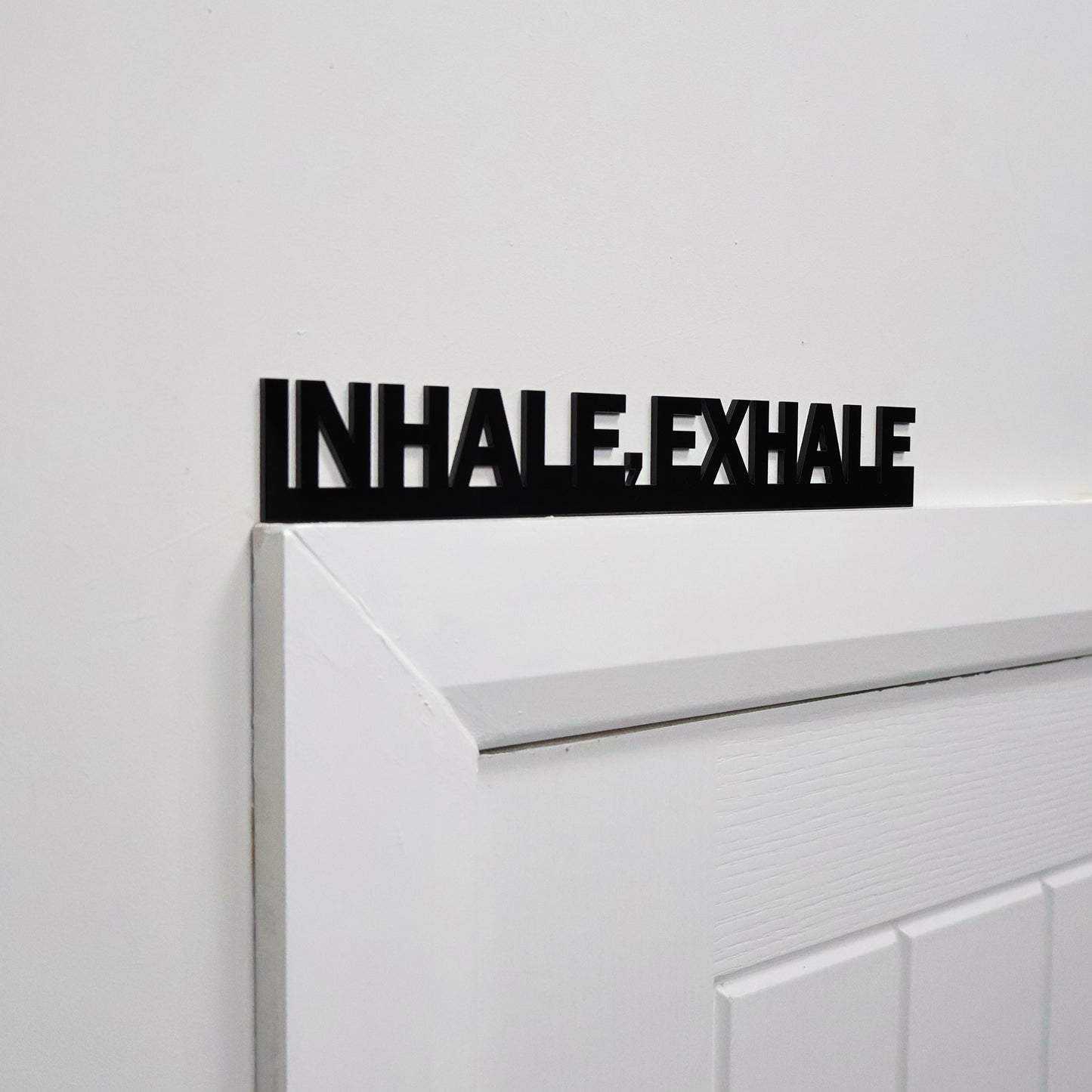 Close-up of smooth acrylic mindfulness sign mounted on wall surface