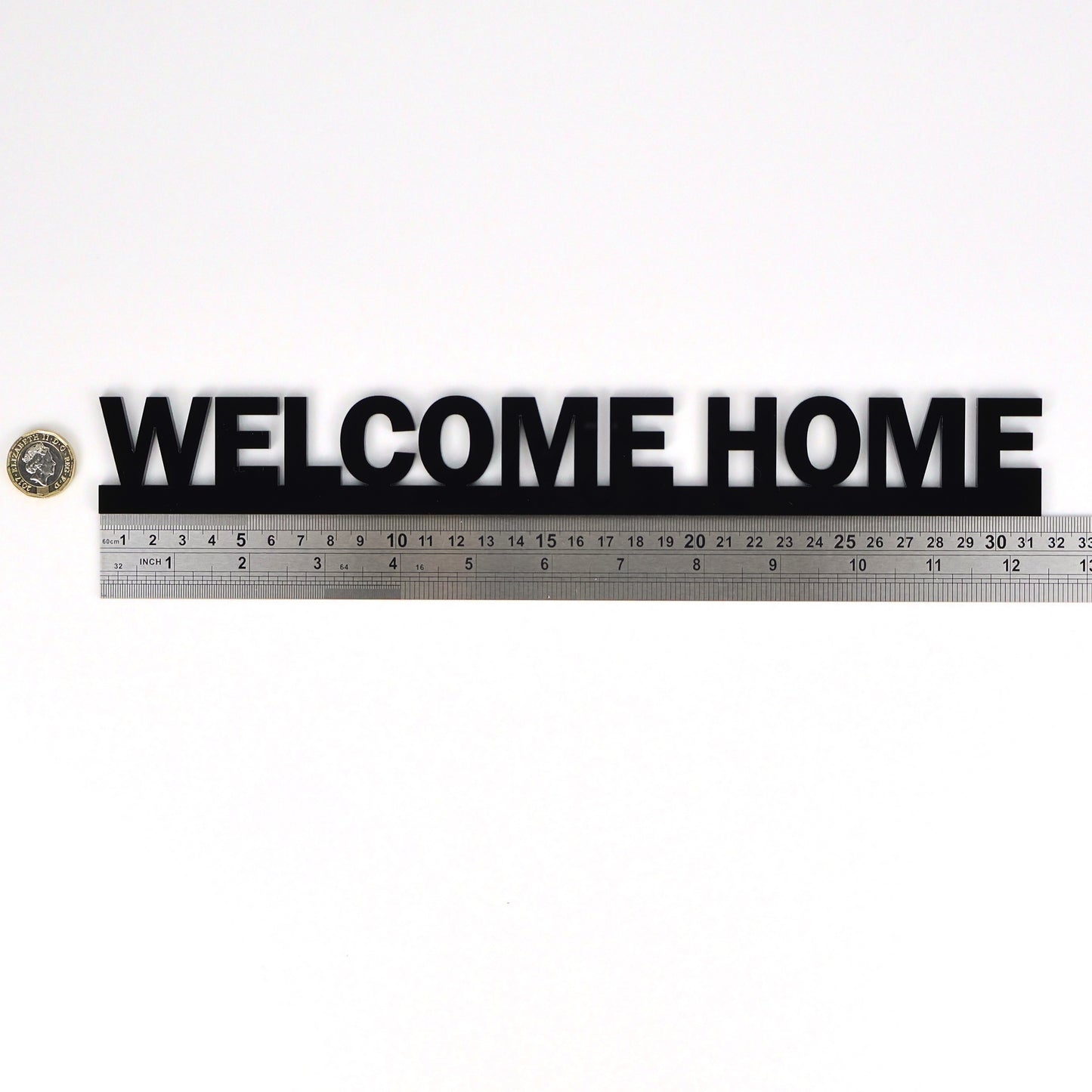 WELCOME HOME Door Topper shown beside ruler and pound coin for scale