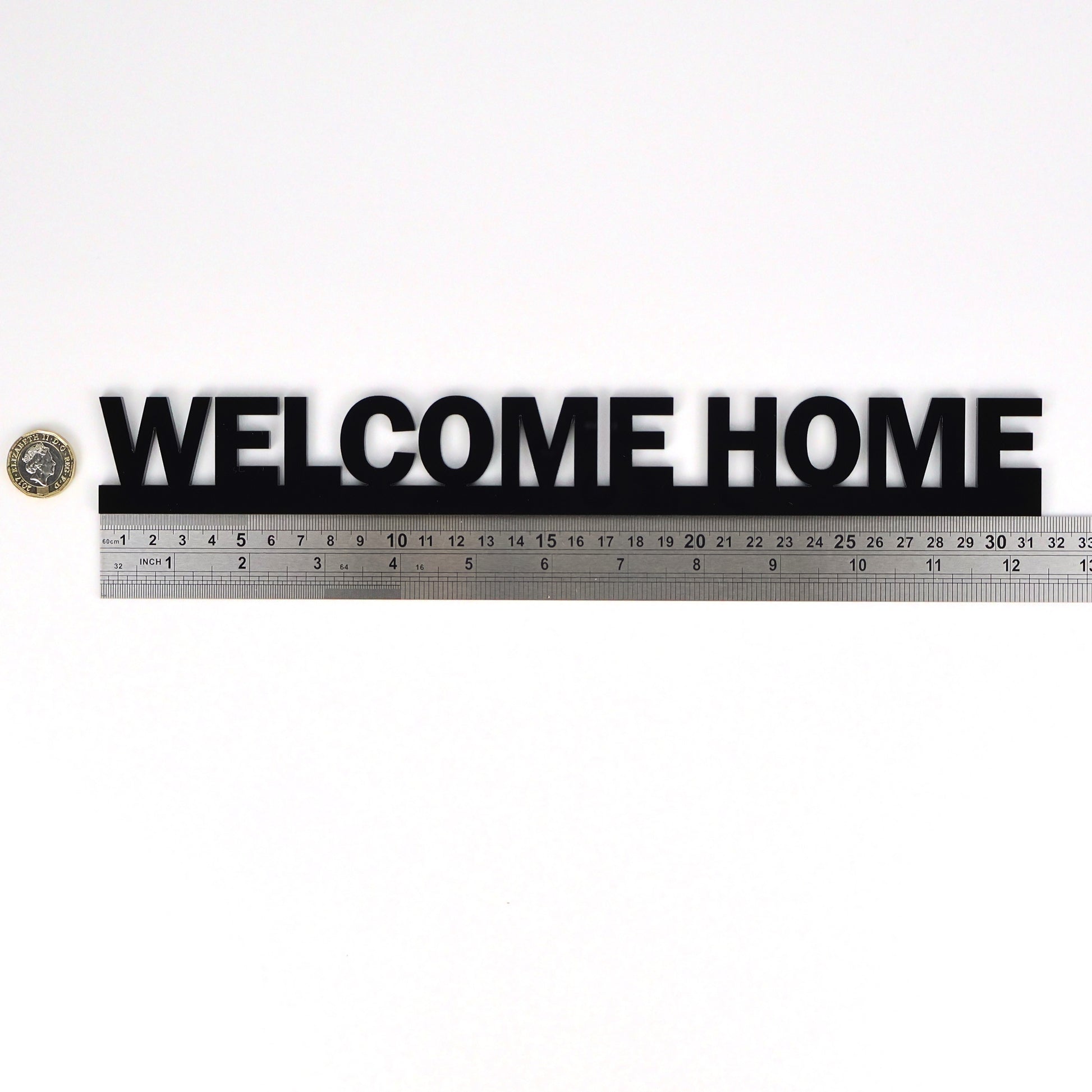WELCOME HOME Door Topper shown beside ruler and pound coin for scale