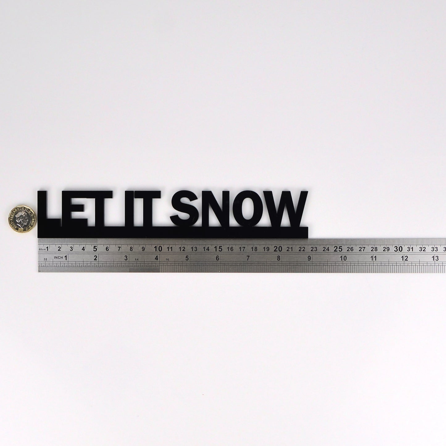 LET IT SNOW wall sign beside a pound coin for size reference