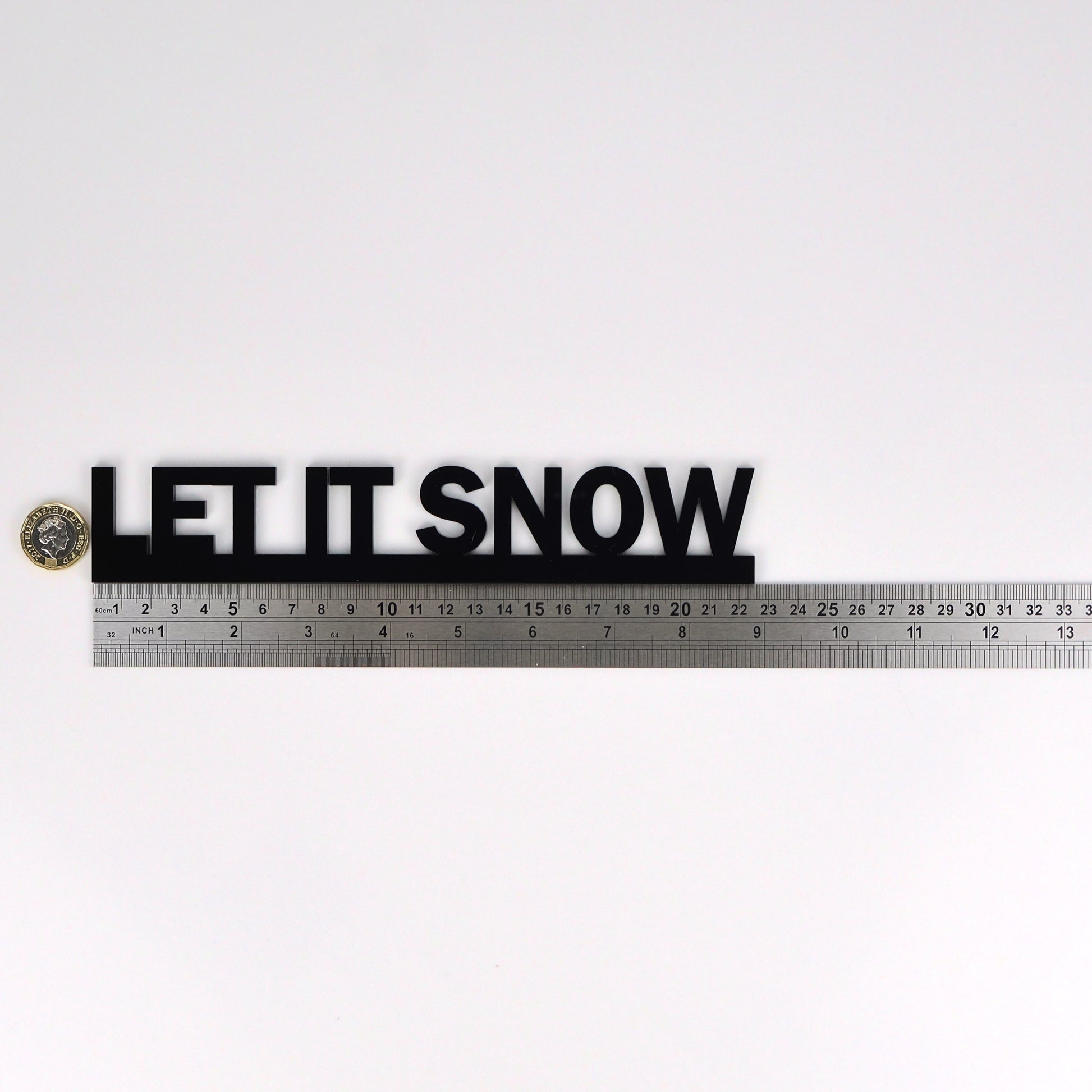 LET IT SNOW wall sign beside a pound coin for size reference