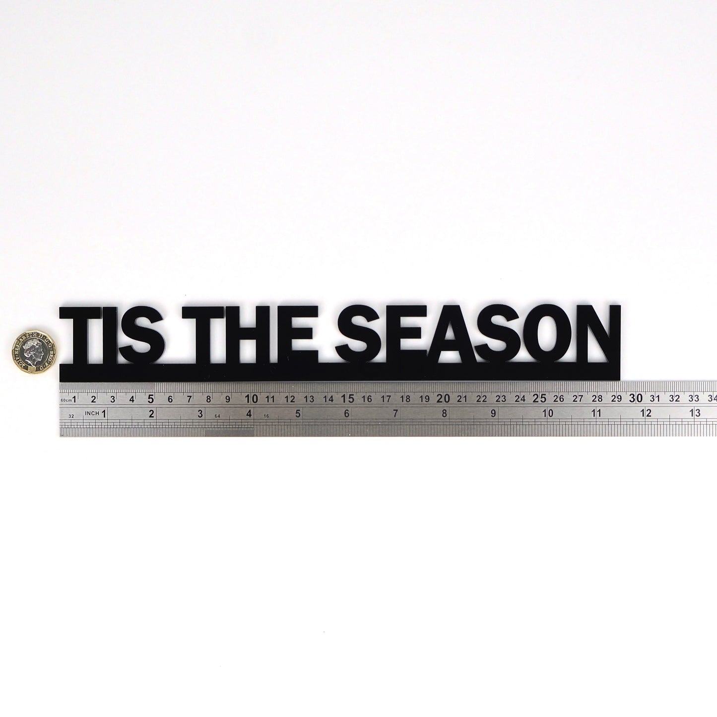 Black acrylic Door Topper shown next to a ruler and pound coin for size and scale