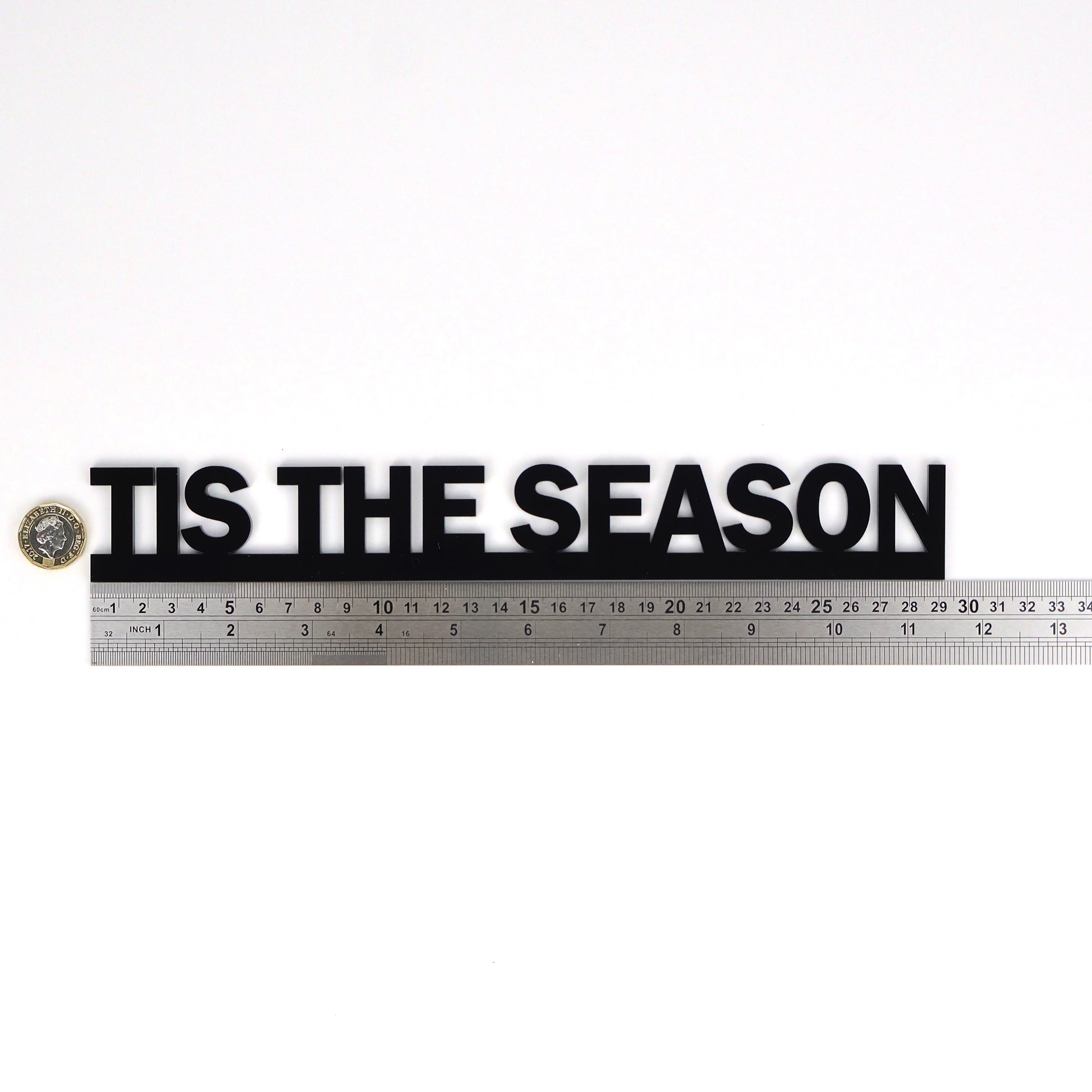 Black acrylic Door Topper shown next to a ruler and pound coin for size and scale