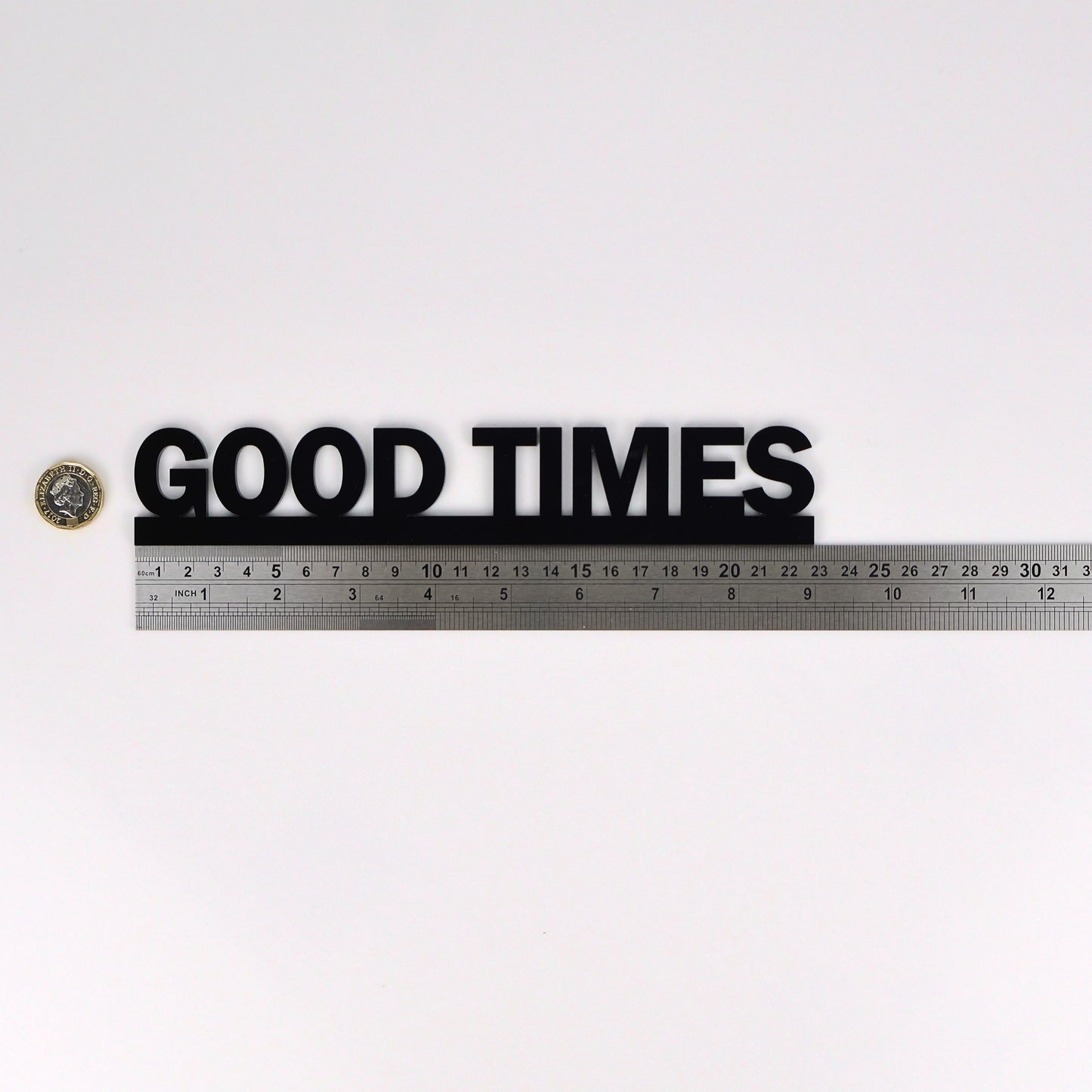 Flat lay showing GOOD TIMES Door Topper beside ruler and pound coin for scale