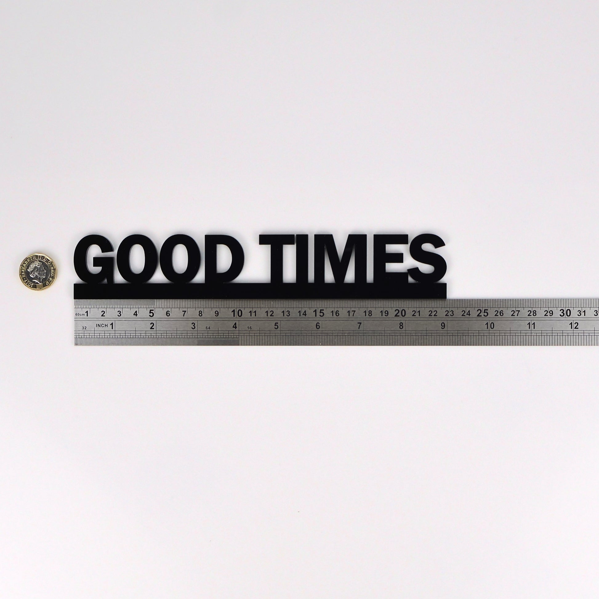 Flat lay showing GOOD TIMES Door Topper beside ruler and pound coin for scale