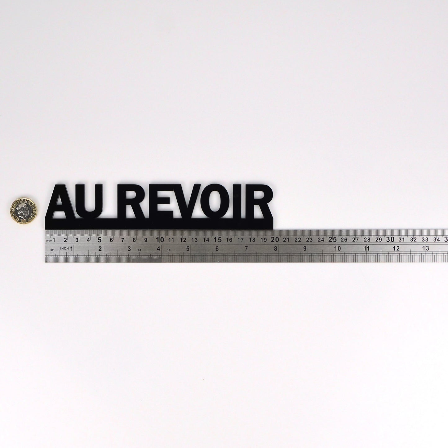 Product size image showing the AU REVOIR sign beside a ruler and pound coin.