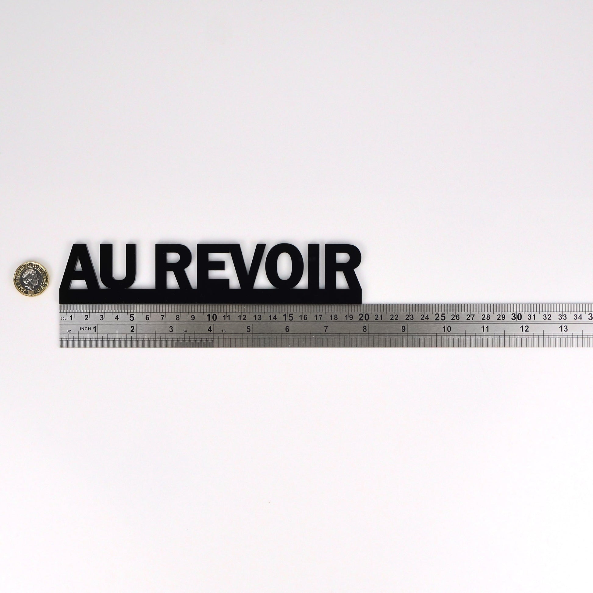 Product size image showing the AU REVOIR sign beside a ruler and pound coin.