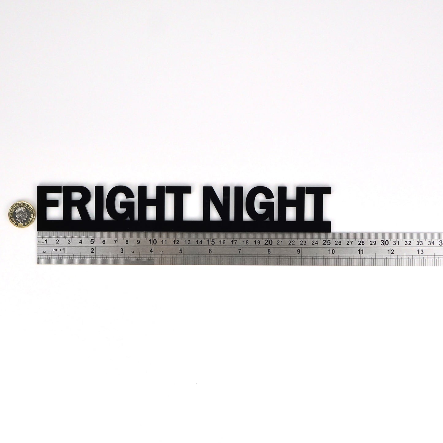 FRIGHT NIGHT wall sign beside a pound coin for size reference