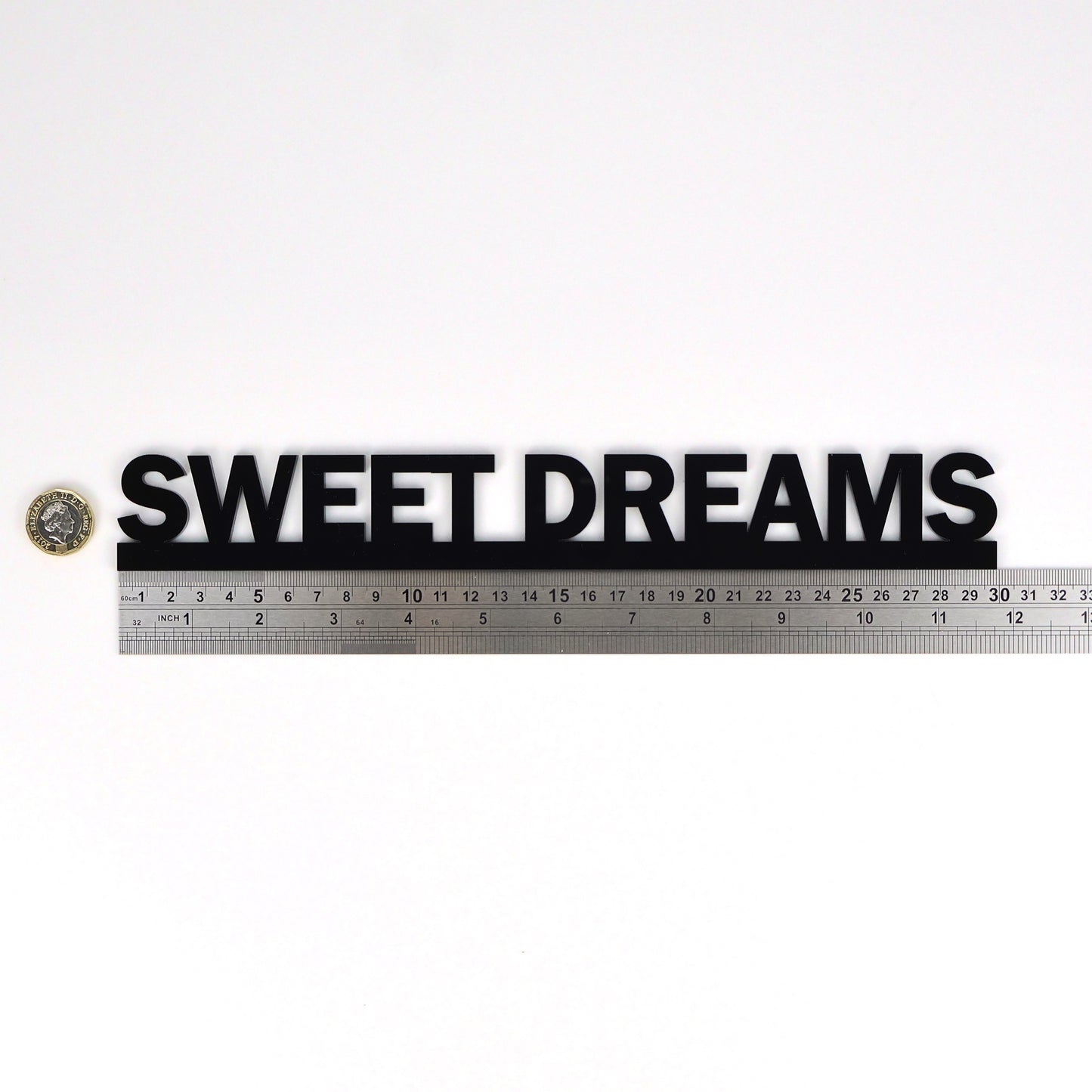 Size reference – sign beside ruler and pound coin