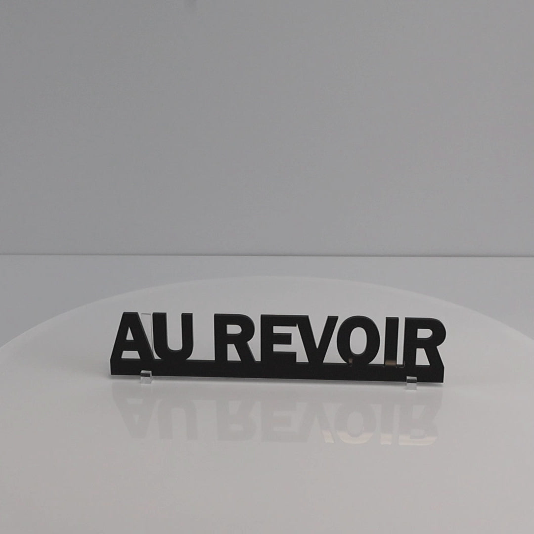 Rotating close-up video highlighting the smooth gloss finish of the AU REVOIR sign.